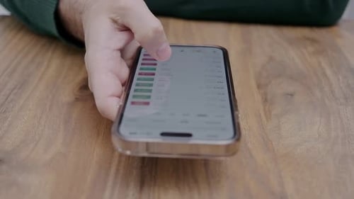 Man Hand Holding Smartphone with Currency Stock Trading App on Screen Financial Analysis Shares