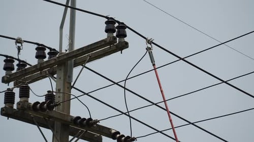 eletricista usando braçadeira (ferramenta isolada) para restaurar a energia no poste elétrico