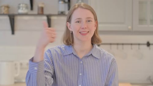 Smiling Woman Gives Thumbs Up in Kitchen