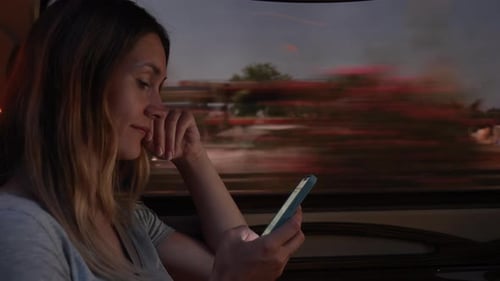 Woman Uses Mobile Phone on Moving Bus at Night