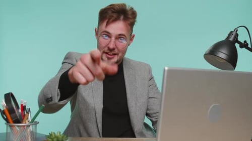 Lächelnder Geschäftsmann zeigt in die Kamera und wählt einen glücklichen Gewinner aus, der darauf hinweist, dass Sie eine tolle Werbeaktion haben