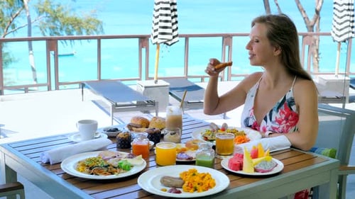 Young Woman Eating Sunday Brunch or Breakfast in Outdoors Restaurant at Luxury Hotel on Vacation