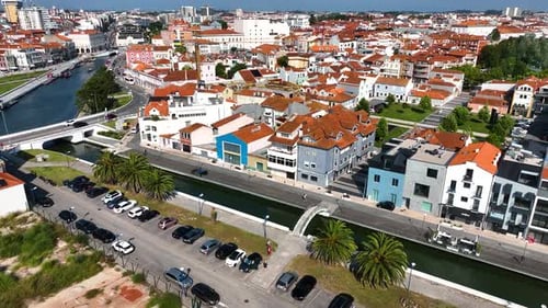 Canal bridge with people and red-roofed homes in Aveiro