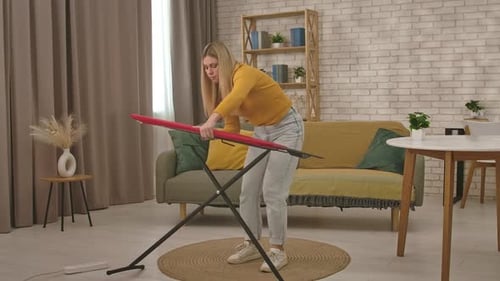 Woman Assembling Ironing Board in Cozy Home Interior