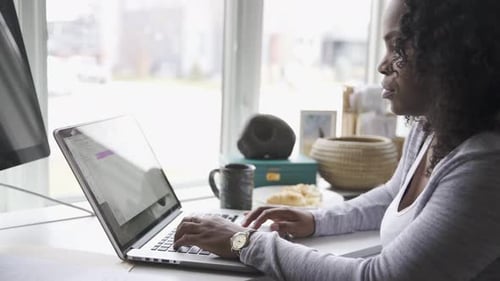 Woman Working At Laptop In Home Office