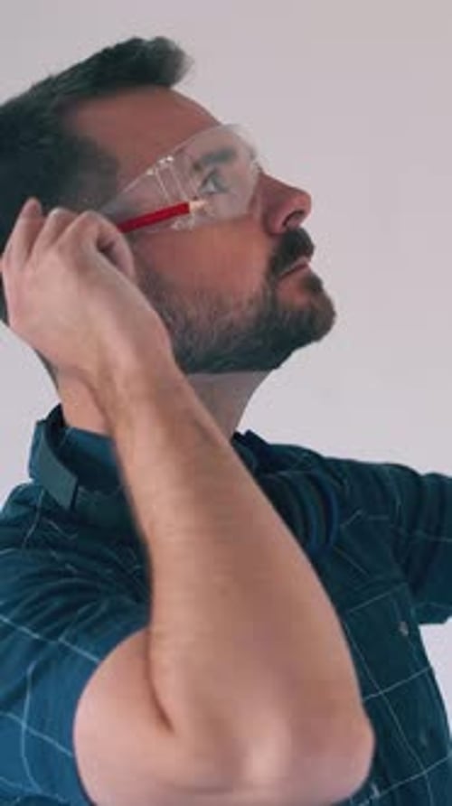 Builder in Shirt Uses Level to Check Wall Angle in Room