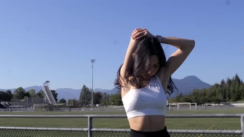 Athletic Woman Stretches on Sunny Outdoor Track