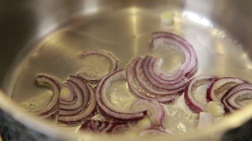 Red Onion Slices Sautéing in Pot Close Up