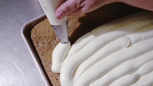 Piping Cream onto Delicious Cake Dessert
