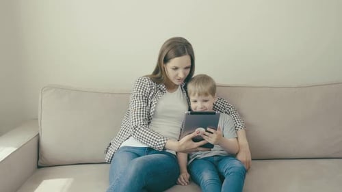 Woman and Child Smiling at Tablet Device