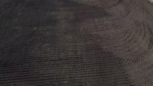 Flight Over a Plowed Field of Black Soil on a Sunny Day A Dug Up Field of Earth