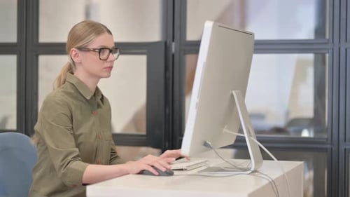 Young Adult Working at Computer Massages Temples