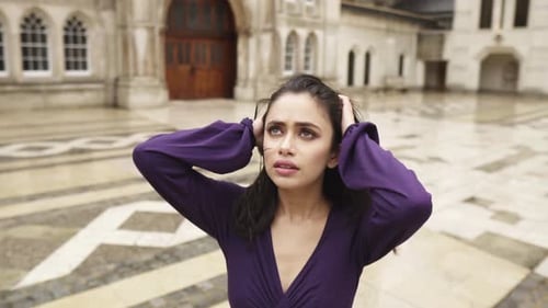 Middle Eastern young attractive woman is looking desperate in the sky while holding her head depress