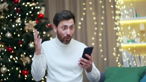 Man Celebrates While Looking at Phone at Christmas