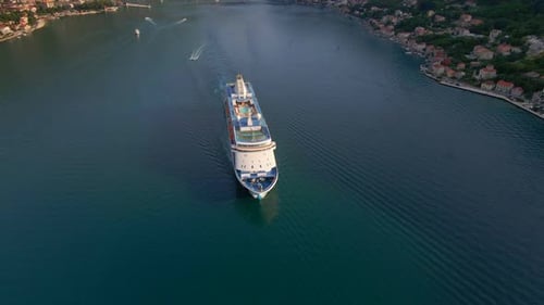 The Drone Captures a Stunning Aerial View of a White Cruise Ship Leaving the BokaKotor Bay in