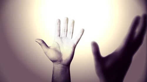 Hand reaches up toward glowing light, arm visible