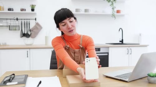 Woman Showing off New Smartphone in Kitchen