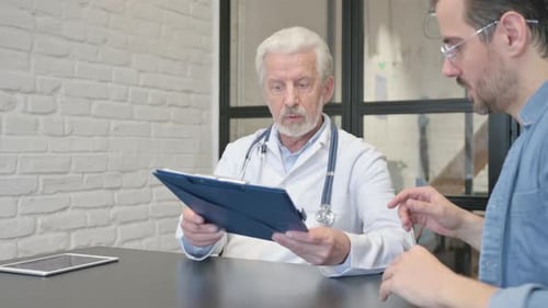Doctor Discusses Chart with Adult Patient in Office