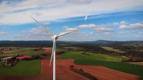Windmill turbine rotating against blue sky