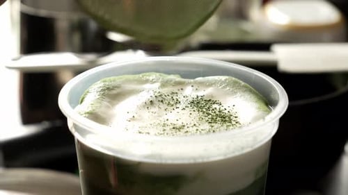 Matcha powder spread on a sieve to a matcha drink. Close up