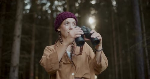 Female Explorer with Binoculars in Forest