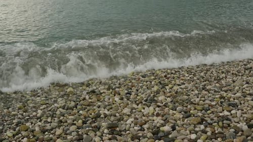 Sea waves, breaking against the rocks, make them smoother with each motion. In Slow Motion.