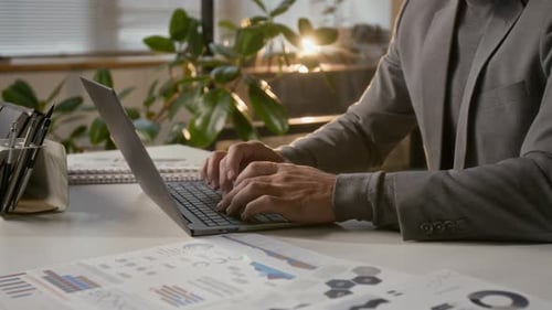 Midsection of Unknown Businessman Working on Laptop at Office Desk