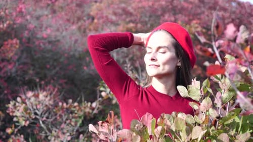 Young Beautiful Sensual Woman in a Red Sweater and Beret Posing in the Autumn Forest Against a