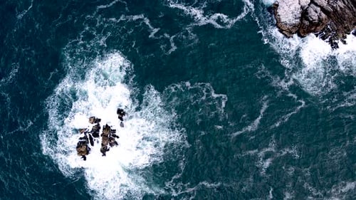 Atlantic swell surge around sea rocks and coastline, dramatic top-down aerial