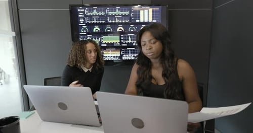Two Women Working at Laptops in Modern Office