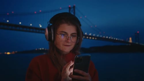 Young Woman Use Phone and Stream Music From App