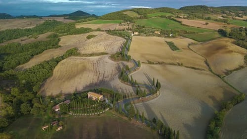 Explore the Winding Roads of Tuscany Italy As the Sun Sets Behind Rolling Hills and Farmland