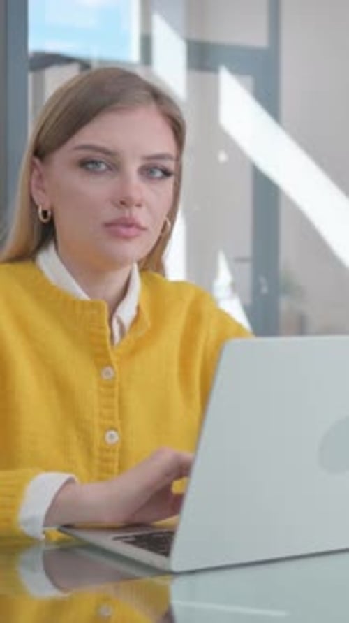 Woman Works on Laptop in Bright Office Setting
