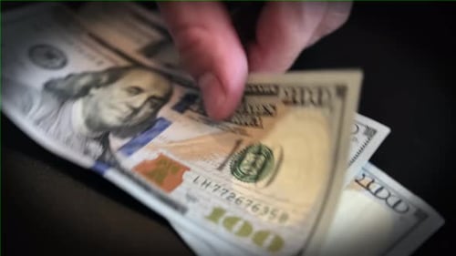 Männliche Hände zählen US-Dollar-Scheine in bar auf schwarzem Hintergrund, Nahaufnahme. US-Geldscheine
