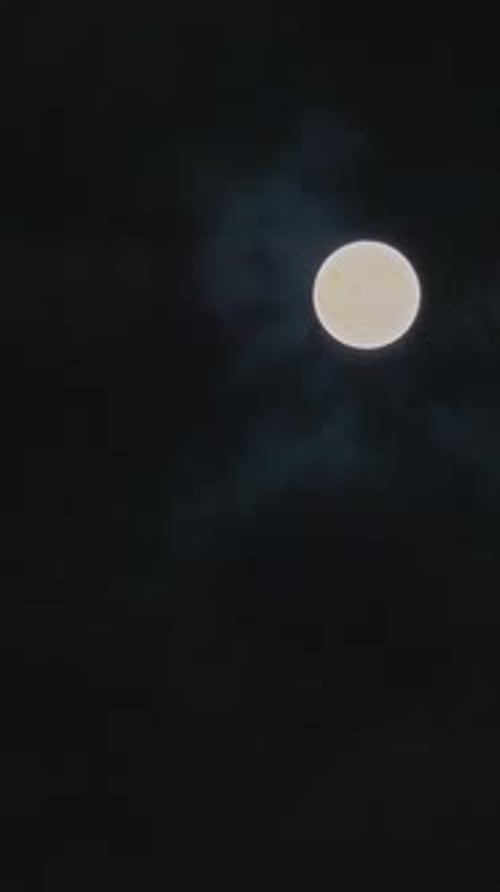 Vertikaler Mond, der sich zwischen Wolken bewegt