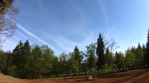 Man on Motocross Bike Jumping Over Dirt Track