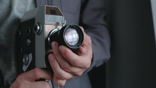 Holding a Gray and Silver Vintage Camera