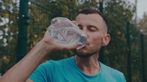 Man Drinking Water After Intense Workout Outdoors