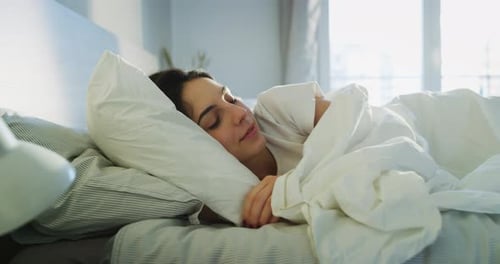 Woman Wakes Up and Stretches in Bed