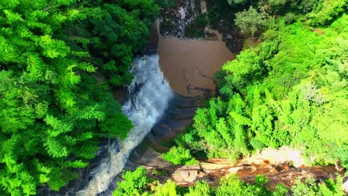 Stunning waterfall with cascading tiers, embraced by lush greenery.