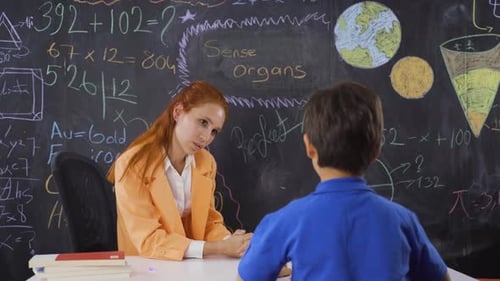 Teacher Explaining Lesson to Student in Classroom