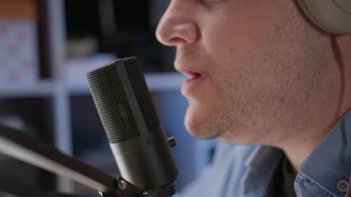 Close Up View of Microphone and Mouth of Unrecognizable Man in Blue Shirt Singing in Recording