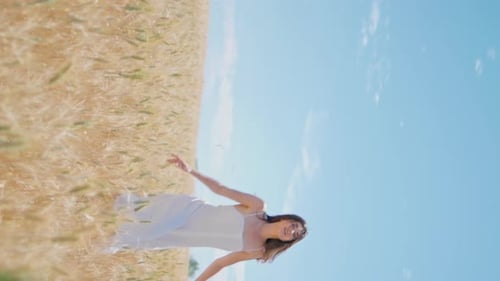 Молодая женщина, движущаяся колосками, луг, вид сзади, вертикальная девушка, бегущая по пшеничному полю