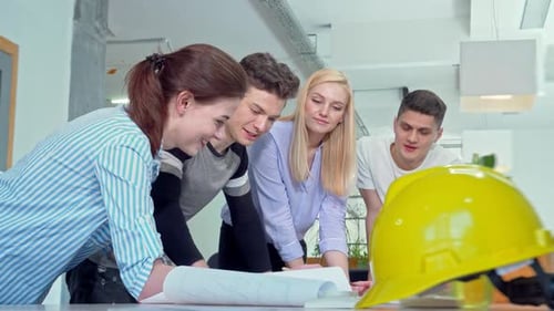 Architects Collaborating on Plans in Modern Office