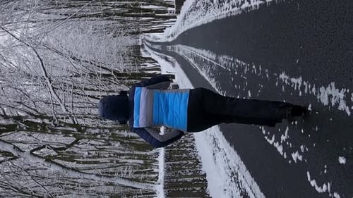 Vertical Video A Woman Runs Along a Forest Road The Trees are Covered with Snow