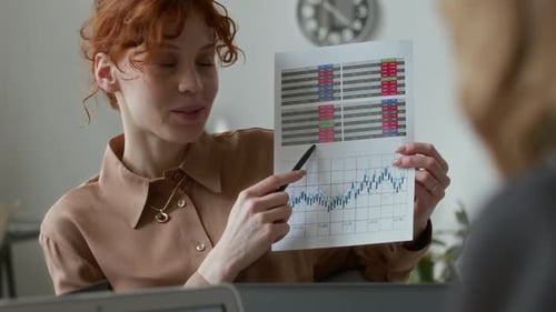 Businesswoman Explains Chart in an Office Setting