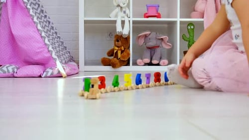 Child Plays with a Number Train in Playroom