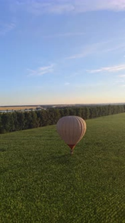 Aerial Scenery of Hot Air Balloon Flying in the Sky Above Green Field at Summer Day