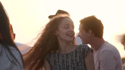 Young Adults Dancing on a Rooftop at Sunset