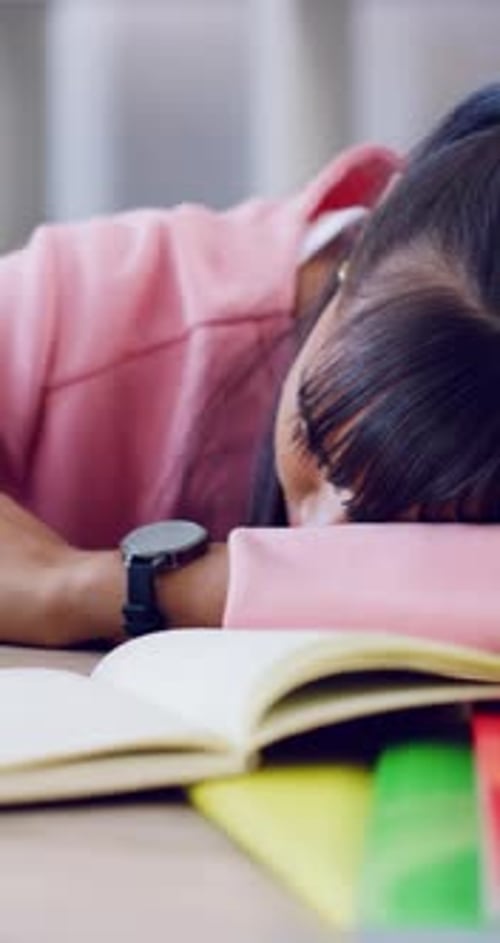 Sleeping, study and teen girl with book, tired and fatigue at desk with homework or revision